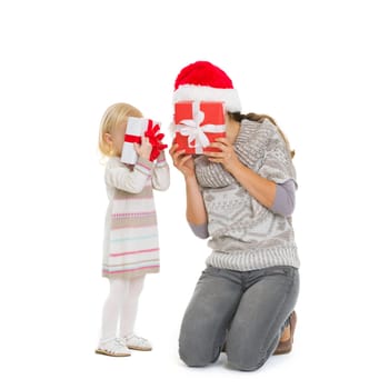 Mother and baby hiding behind Christmas gift boxes