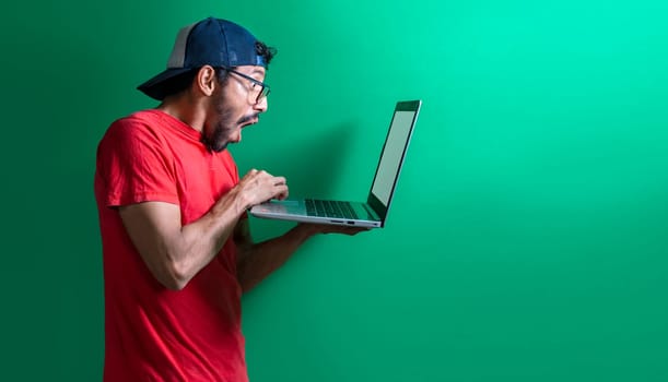 Guy in cap checking his laptop isolated, surprised man checking his laptop