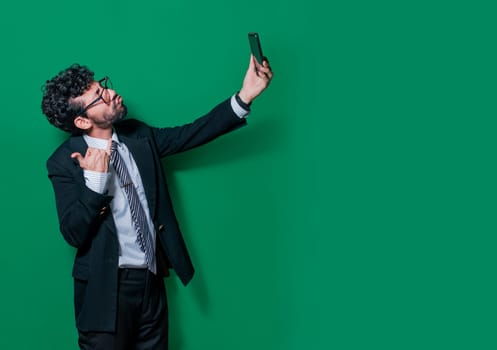 Young businessman taking a selfie with funny gestures, Businessman taking funny selfies isolated, Concept of businessman guy taking a selfie and blowing kisses on the cell phone