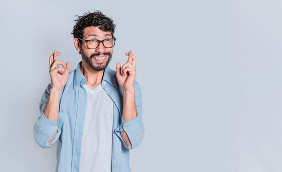 Positive people smiling making a wish while crossing his fingers. Happy man making a wish crossing his fingers, Concept of positive person making a wish and crossing his fingers on isolated background