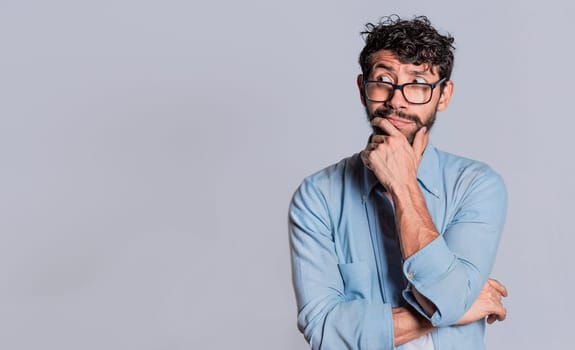 Handsome man wondering with hand on chin looking aside isolated, Person wondering with hand on chin seeing blank space, Concept of thoughtful person with hand on chin