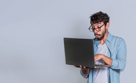 Surprised person looking at an offer on laptop, surprised people looking at a promotion on laptop isolated. Amazed handsome man with laptop isolated.