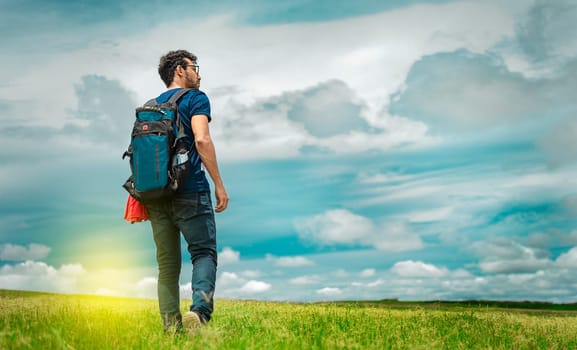 Adventurous man in the field, man with backpack in the field looking