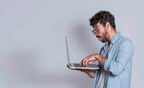 Surprised people looking at a promotion on laptop isolated with copy space. Amazed handsome man with laptop isolated, Surprised person looking at an offer on laptop