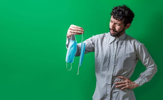 Man deciding which surgical mask to wear, Person deciding to wear a surgical mask in an isolated context, People deciding which mask to wear
