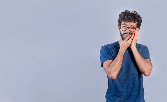 Handsome man with toothache isolated, Person with pulpitis or toothache problem, Concept of people rubbing cheek with toothache