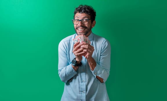 Friendly and happy man with money in his hands looking at the camera, Happy person with money in his hands isolated. Happy person with money in his hands looking at the camera