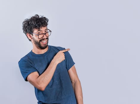 Friendly handsome man pointing two fingers to the side, Smiling handsome man pointing two fingers to the side. Concept of a young man pointing at a banner