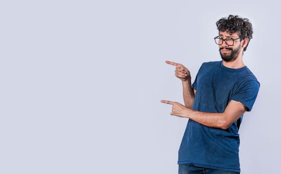 Smiling handsome man pointing two fingers to the side, Friendly handsome man pointing two fingers to the side, Concept of a young man pointing at a banner