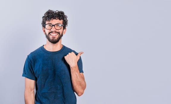 Cheerful friendly man showing you the direction to a nice place, friendly person pointing thumb to the right, smiling people pointing to the right on isolated background