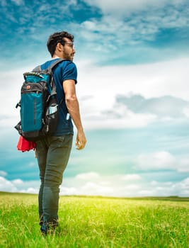 Adventurous man in the field, man with backpack in the field