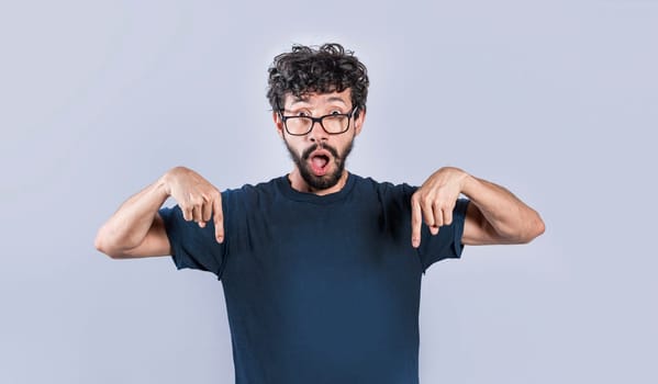 Amazed man pointing down isolated, Shocked person pointing down with fingers isolated, Amazed young man pointing down