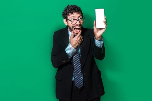 Businessman showing an advertisement on the screen of his cell phone. Amazed handsome business man showing cell phone screen, Surprised young businessman showing cell phone screen