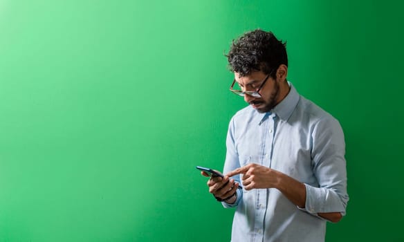 Isolated person checking his cell phone, Teenage guy checking his cell phone isolated, View of handsome man using a cell phone isolated