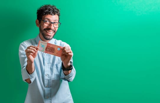 Happy person showing you a single bill. Friendly man with a smile showing one money bill isolated, Concept of person showing a 500 Nicaraguan cordobas bill.