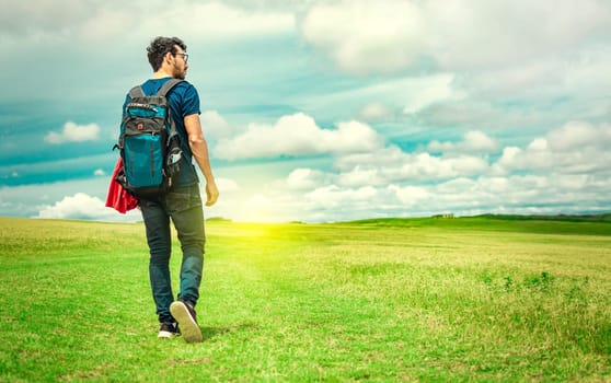 Adventurous man in the field, man with backpack in the field looking