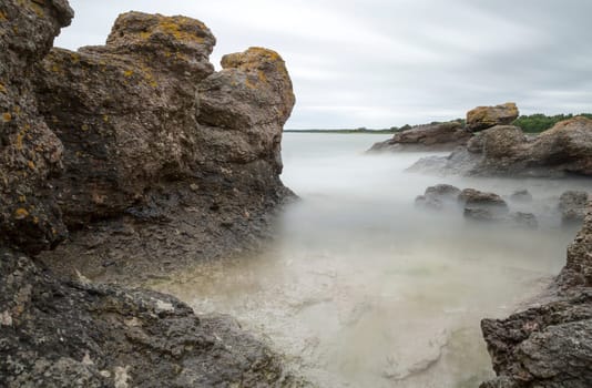 Sea Stack by Ocean in Gotland, Sweden with clouds in the sky.