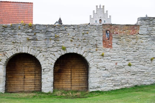 Wooden Doors in the town-wall of Visby, Gotland with buildings behind it.