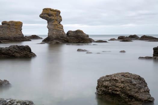 Sea Stack by Ocean in Gotland, Sweden with clouds in the sky.