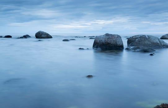 Calm Ocean with Rocks and blue ocean and sky.