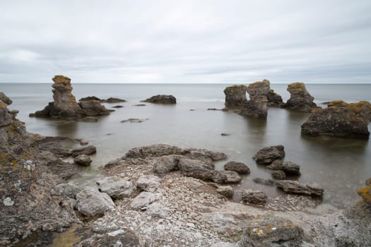 Sea Stack by Ocean in Gotland, Sweden with clouds in the sky.