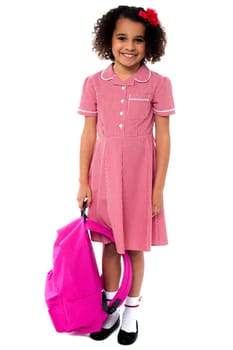 Smiling school girl posing with backpack over white