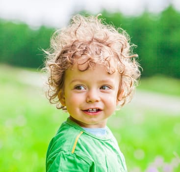 Portrait of 1 year old baby boy having fun on a mountain meadow.