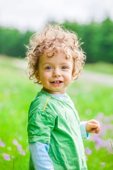 Portrait of 1 year old baby boy having fun on a mountain meadow.