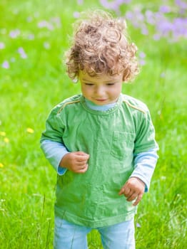 Portrait of 1 year old baby boy having fun on a mountain meadow.
