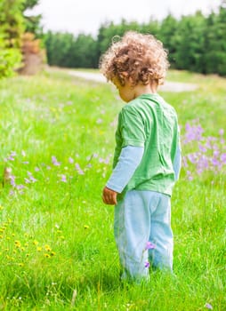 Portrait of 1 year old baby boy having fun on a mountain meadow.