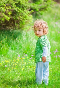 Portrait of 1 year old baby boy having fun on a mountain meadow.