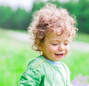Portrait of 1 year old baby boy having fun on a mountain meadow.