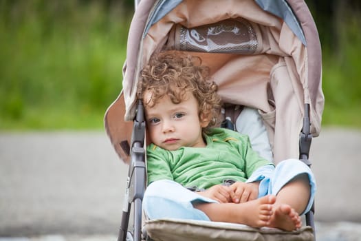 Portrait of 1 year old baby boy in a stroller.