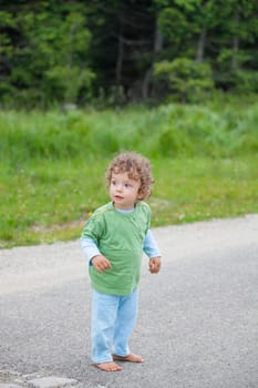 Portrait of 1 year old baby boy having fun on a mountain meadow.