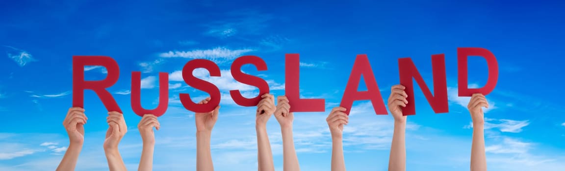People Or Persons Hands Building German Word Russland Means Russia. Blue Sky As Background.