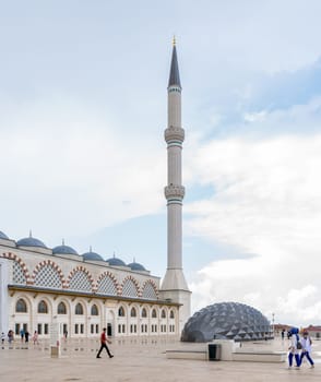 Istanbul, Turkey - August 31 2022: Minaret of Grand Camlia Mosque, or Buyuk Camlica Camii, with few pedestrians, a modern complex for Islamic worship, built in 2019, located in Camlica hill, Uskudar