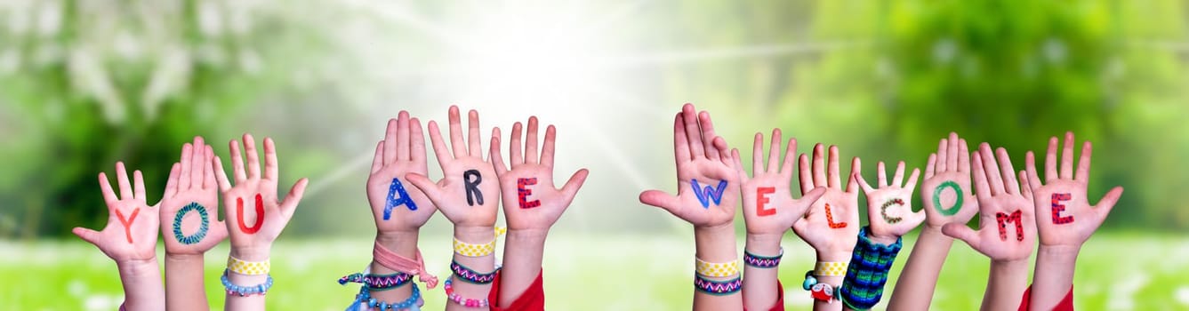 Children Hands Building Colorful English Word You Are Welcome. Sunny Green Grass Meadow As Background.