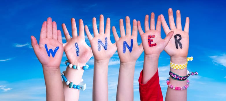Children Hands Building Colorful English Word Winner. Blue Sky As Background
