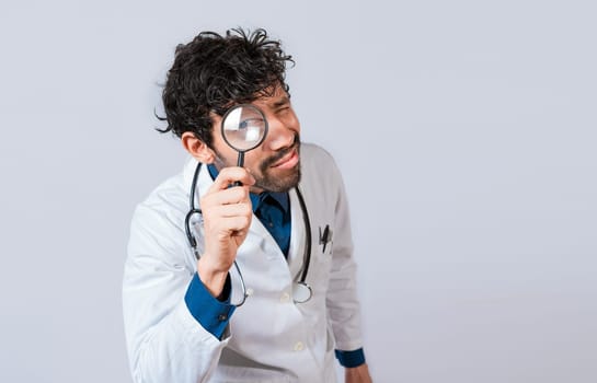 Doctor with magnifying glass looking at the camera. Doctor holding magnifying glass and looking at camera on isolated background