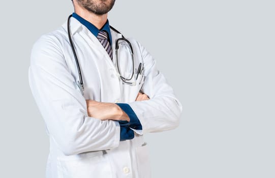 Young doctor with crossed arms isolated. Unrecognizable doctor with crossed arms on isolated background