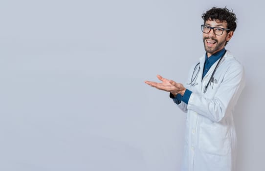 Handsome doctor showing an advertisement with his palms, Smiling doctor showing something with his palms. Young doctor presenting something with palms isolated
