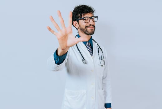 Doctor counting number five isolated. Young doctor counting number 5 on isolated background.