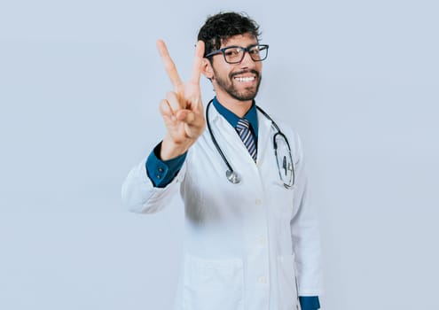 Doctor counting number two isolated. Smiling young doctor counting number 2 on isolated background.