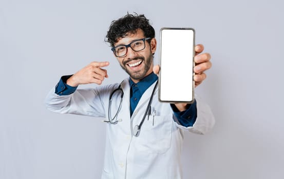 Happy doctor showing cell phone screen to camera. Smiling doctor showing cell phone screen pointing finger isolated.