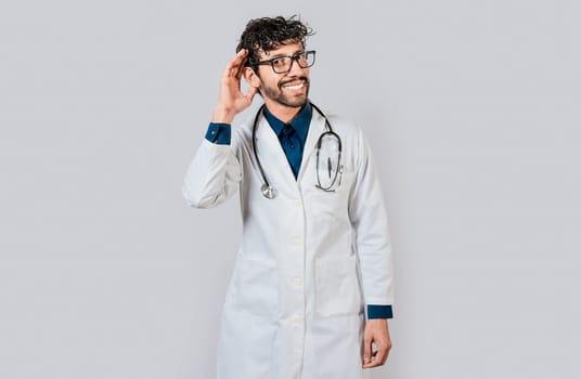 Smiling doctor listening to a rumor. Young doctor smiling with hand over ear isolated, Smiling doctor extending hand isolated