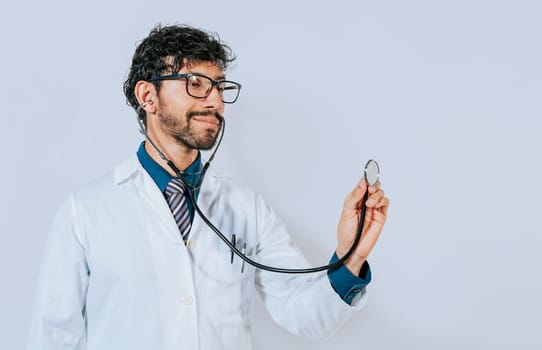 Handsome doctor holding stethoscope on white background. Portrait of male doctor holding isolated