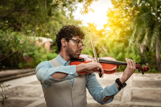 Portrait of man playing violin at sunset. Close up of violinist man playing in the street. Violinist artist playing a melody outdoors, Image of a person playing the violin outdoors