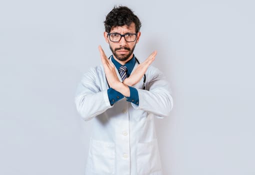 Young doctor making stop sign with hands isolated. Doctor making a stop gesture with palms on isolated background