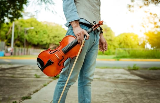 Hands holding violin and hoop outdoors, Close up of hands holding violin and hoop. Concept of person holding violin and hoop outdoors