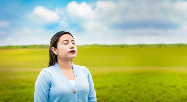 A young woman breathing deeply in the field, A young girl breathing fresh air in the field, Young woman breathing fresh air in the field in the morning